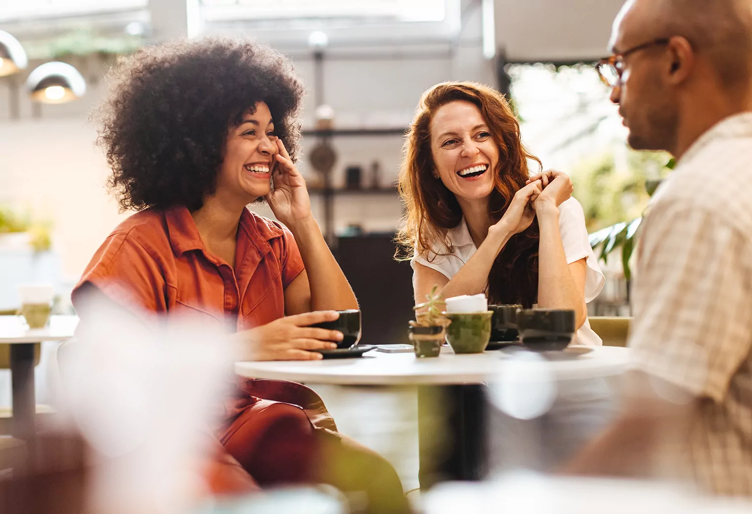 Friends in a cafe having coffee and laughing